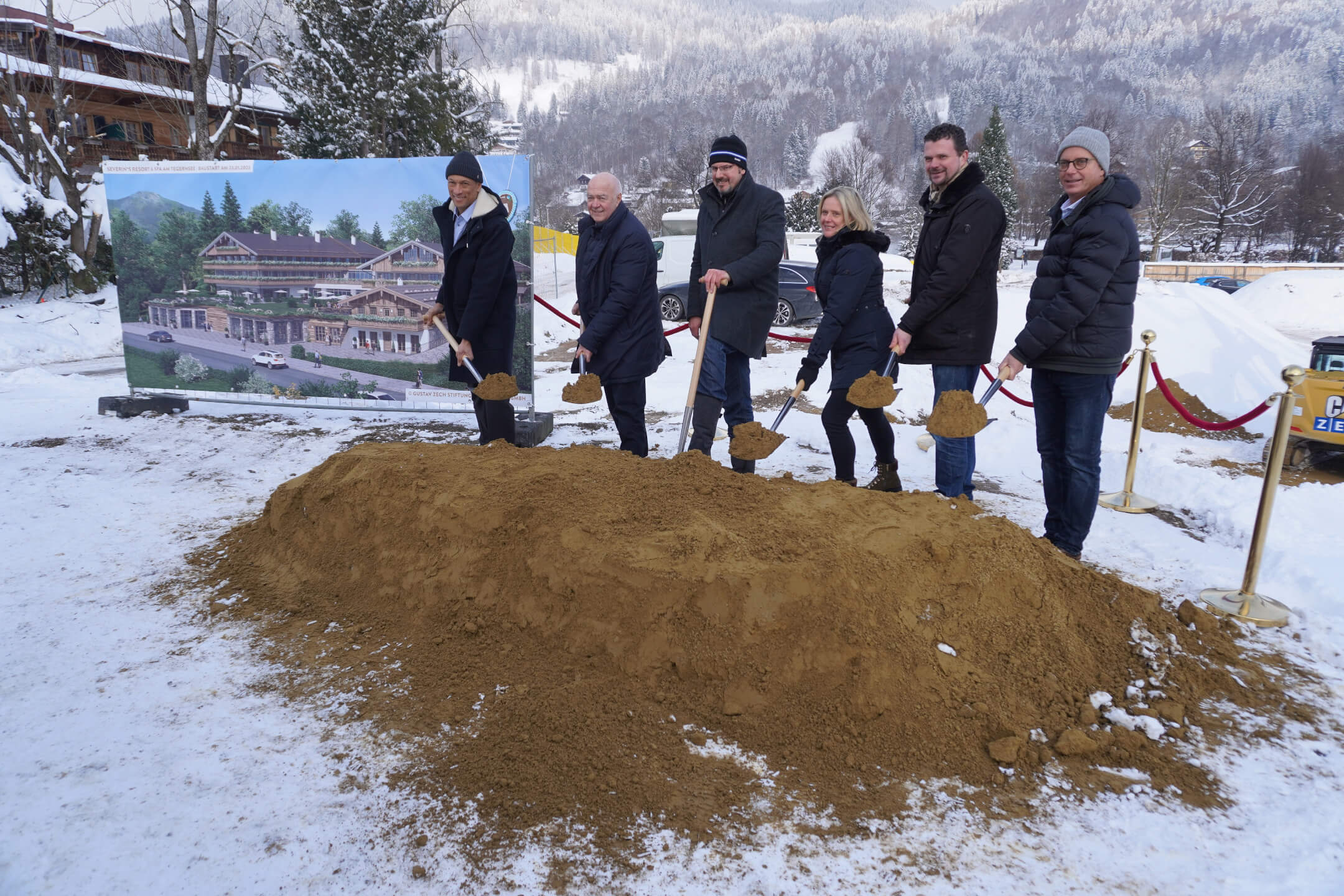 Personengruppe beim Spatenstich für das Severin*s Resort & Spa am verschneiten Tegernsee.