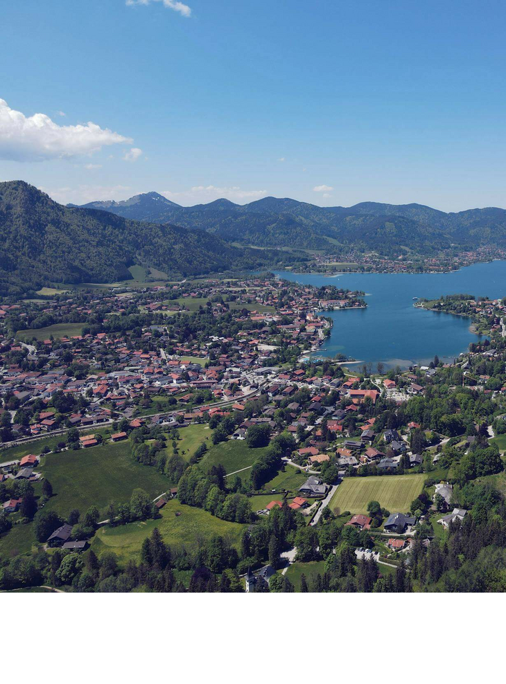 Luftaufnahme des Tegernsees, umgeben von Bergen und grüner Landschaft, nahe dem Severin*s Resort & Spa.